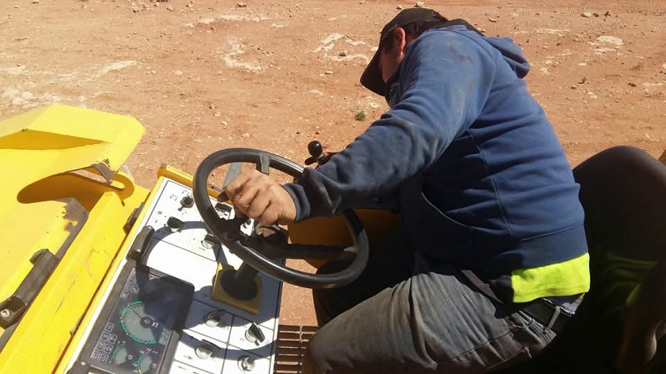 Hands-on repair work underneath heavy equipment. tractor and civil machinery alike.