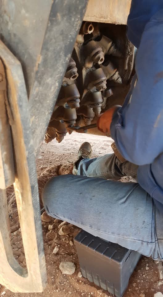 Close-up mechanical inspection and repair on heavy machinery.